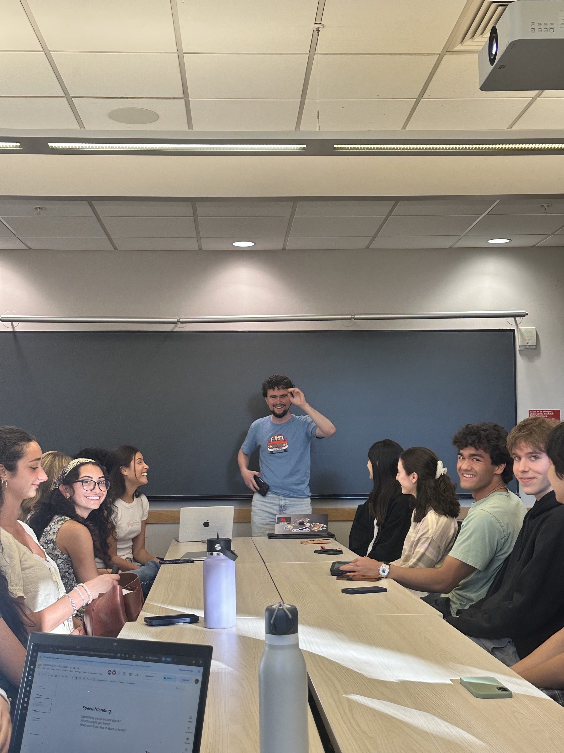 Zach Macaskill-Smith leads a speed-friending icebreaker while fellows laugh around the table